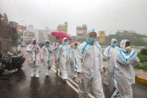 covid health workers walk in rains